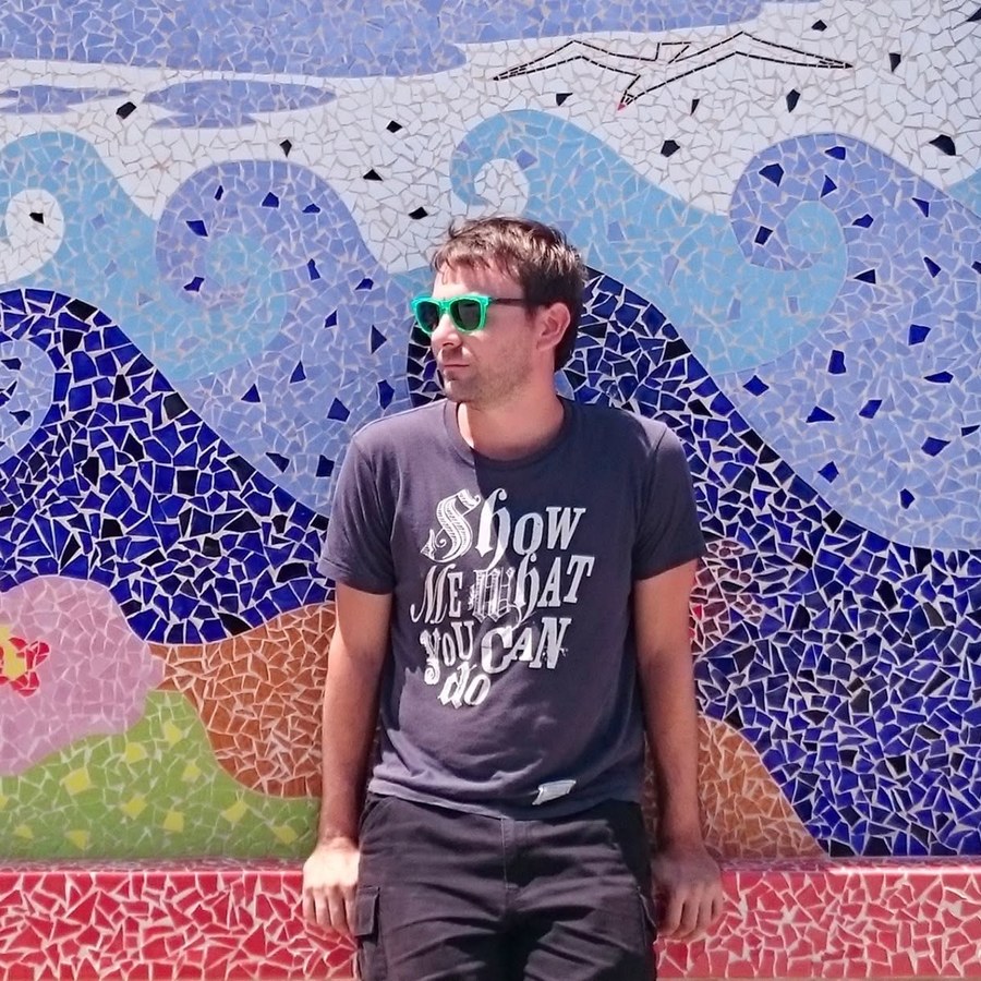 Carlo Gavanelli davanti a un mosaico, con occhiali da sole verdi